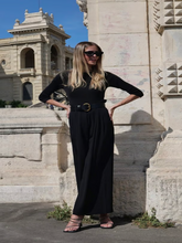 A woman wears a modest sweater and pants